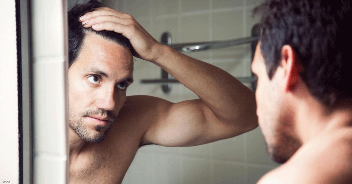 Man touching his hair looking mirror