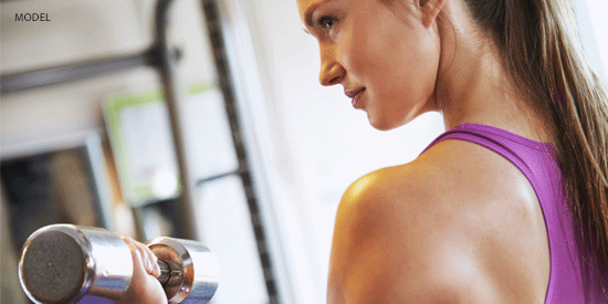 Woman doing a bicep curl with a silver dumbell