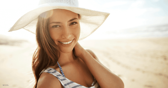 Woman wearing a floppy hat and striped top at the beach