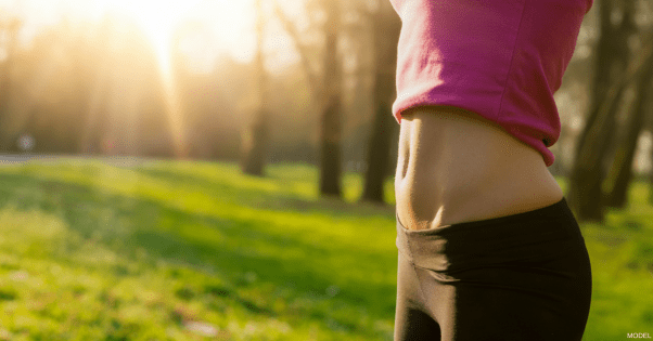 Woman's flat, firm abdomen with tshirt pulled up to show it