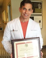 Dr. Calobrace holding framed award