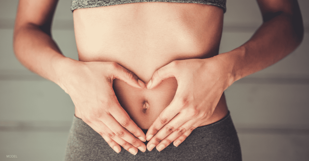 Woman with her hands over her bellybutton after experiencing weight gain after her tummy tuck procedure.