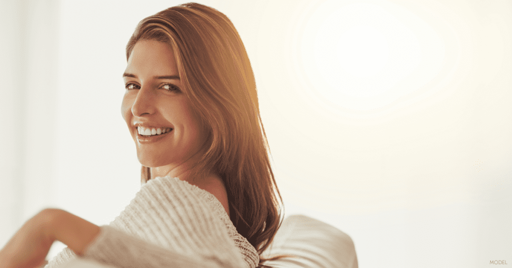 Woman considering what to ask her plastic surgeon about breast augmentation.