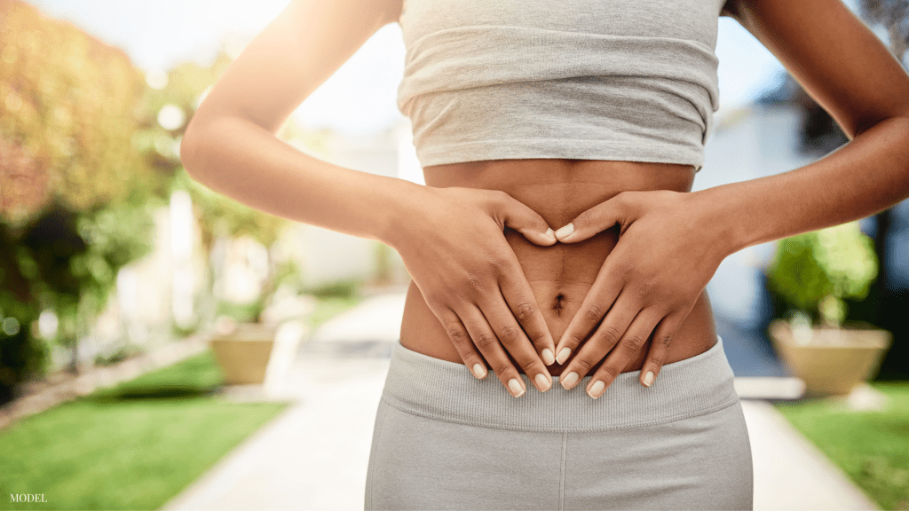 Woman with hands on stomach (model)