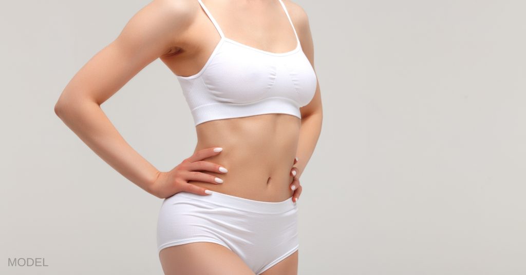 Closeup shot of a beautiful sculpted female body in a studio (model)